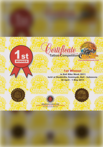 A client sits patiently as a tattoo artist of Caucasian descent sketches a custom design inspired by Balinese culture and scenery. The studio is filled with photographs of Bali and previous tattoo works, showing the deep connection between the art and the island.